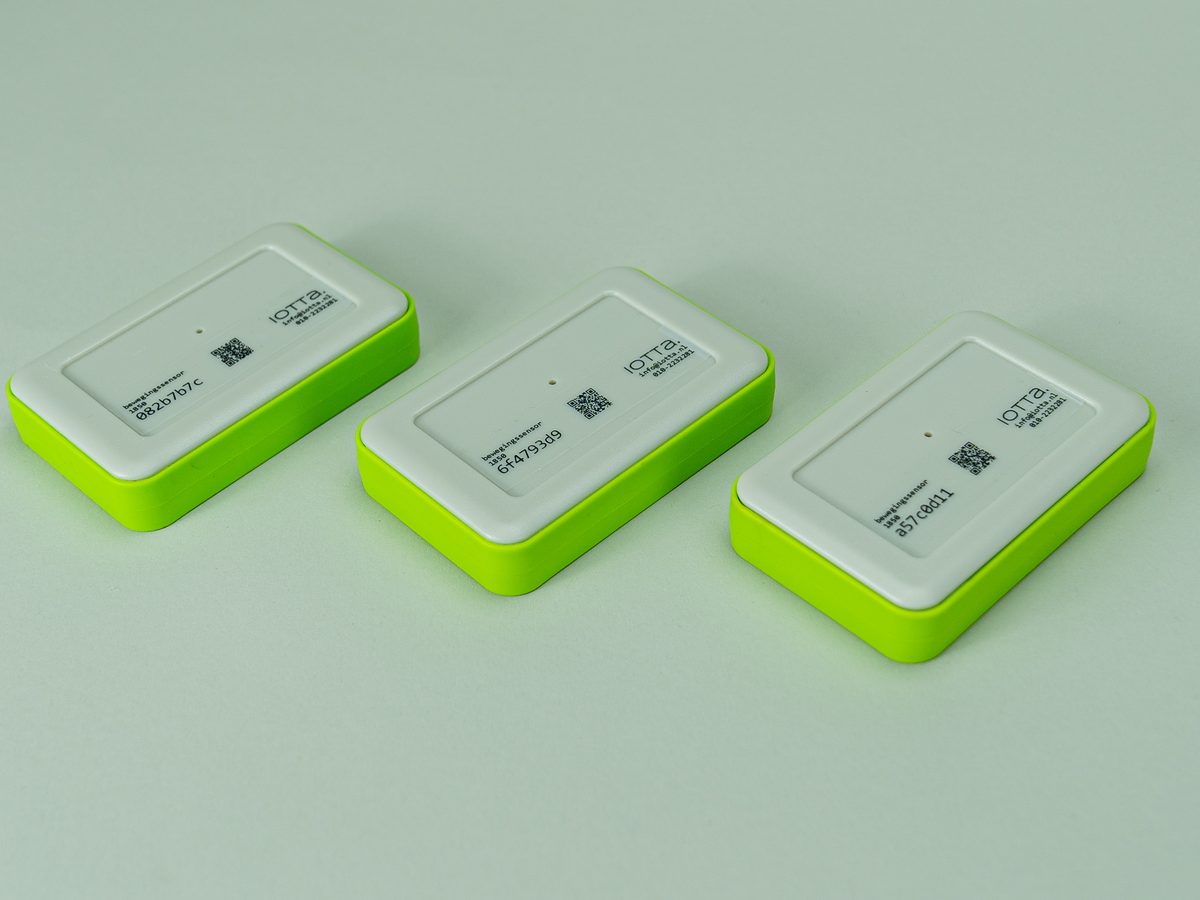 Drie draadloze iotta-werkpleksensoren met groene behuizing, naast elkaar op een neutrale ondergrond
