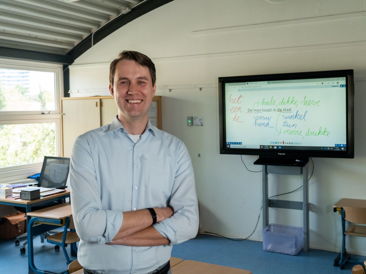 Leslokaal met digitaal schoolbord en leerlingtafels, waar continu het binnenklimaat wordt gemeten